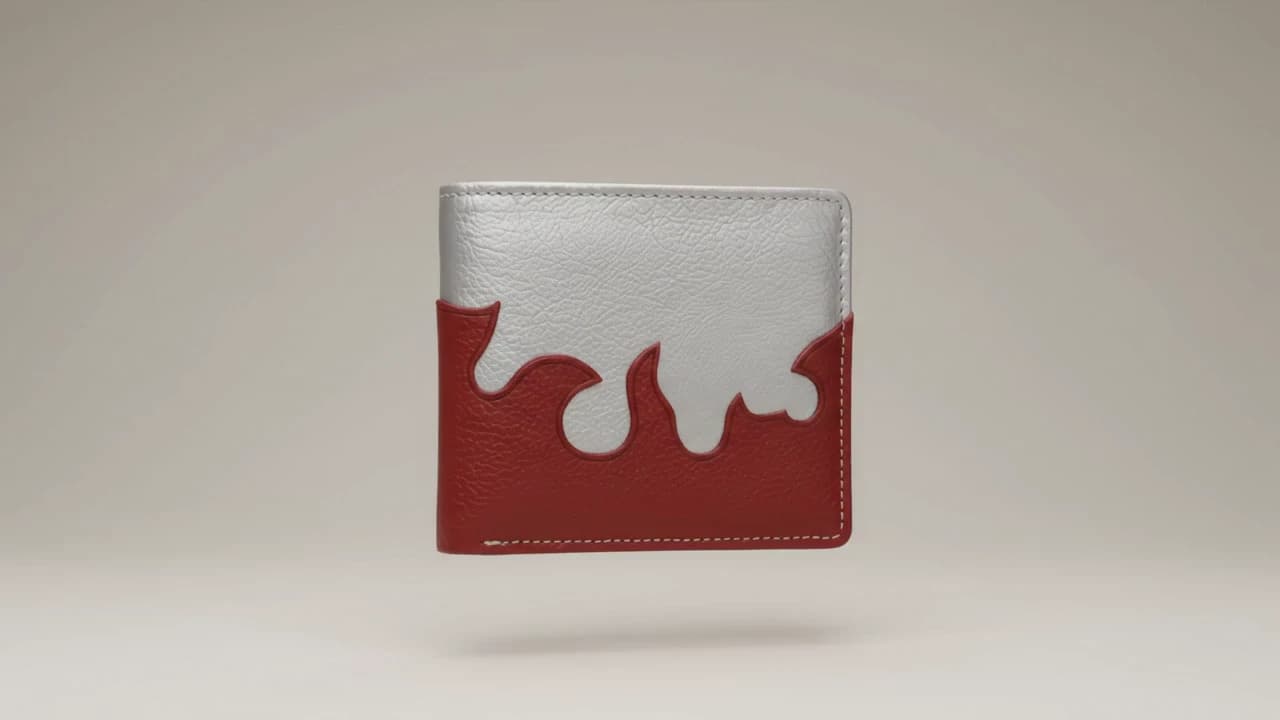 A handcrafted bifold wallet in silver and deep red faux leather, standing against a studio backdrop